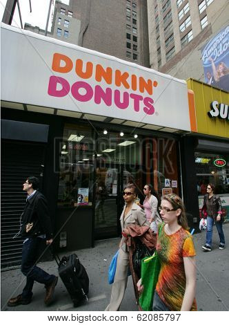 NEW YORK CITY - APRIL 19: Pedestrians walk past a Dunkin' Donuts franchise in New York City, on Friday, April 19, 2013.