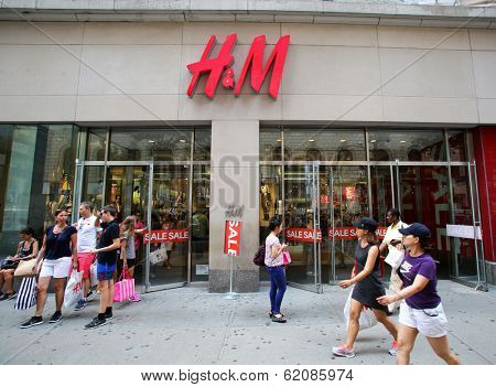 NEW YORK CITY - JULY 8: Shoppers walk past a H&M retail clothing store in New York City, New York, on Monday, July 8, 2013. H & M Hennes & Mauritz AB is a Swedish company.