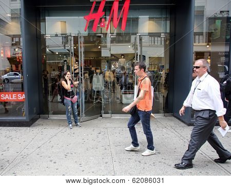 NEW YORK CITY - JULY 8: Shoppers walk past a H&M retail clothing store in New York City, New York, on Monday, July 8, 2013. H & M Hennes & Mauritz AB is a Swedish company.