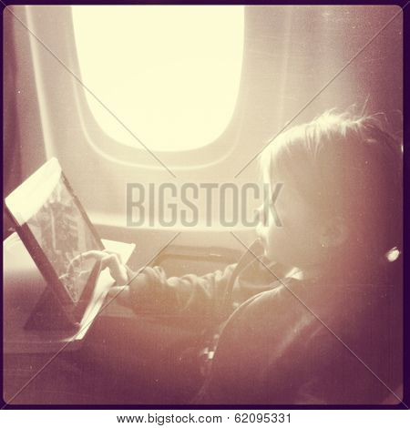 Little girl on Airplane with tablet - instagram effect