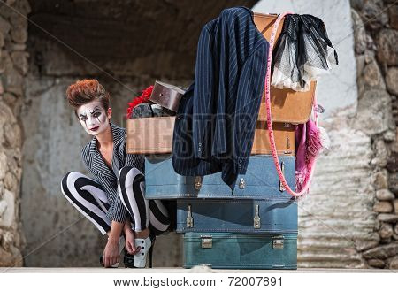Grinning Clown Near Suitcases