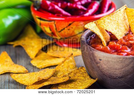 Salsa with tortilla chips and chilli peppers.Concept