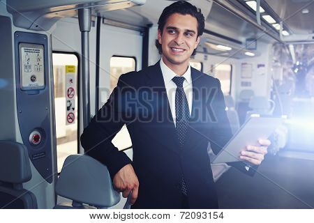 Businessman working with tablet during going to work in train