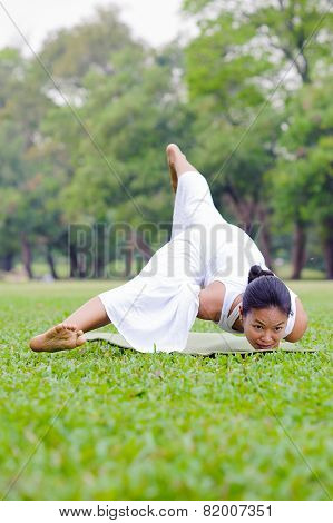 Beautiful Woman Practicing Yoga In The Park
