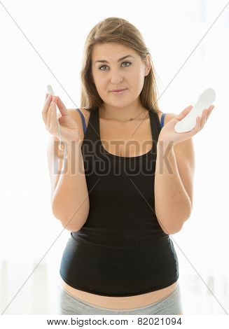 Brunette Woman Holding Menstrual Pad And Tampon