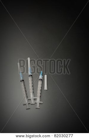 Three vaccination syringes on black