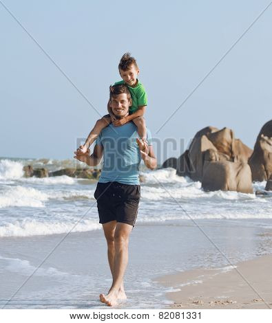 happy family on beach playing, father with son walking sea coast