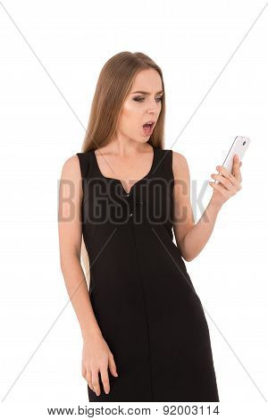 Girl In A Black Dress On A White Background. Girl Talking On The Phone. Angry Girl