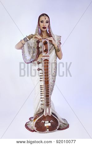 Beautiful Indian Woman In Sari With Oriental Jewelry Posing With Sitar