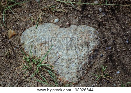 Close-up Of Natural Heart Shaped Granite Stone In Field Soil