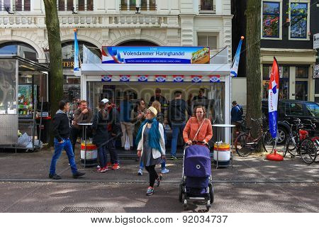 Amsterdam, The Netherlands - May 15, 2015: Locals and tourist at one of Amsterdam's famous Herring street shop
