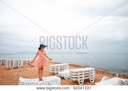 Woman on the deserted beach with many sunbeds