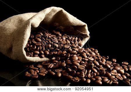 Overturned Bag Full Of Coffee Beans On Black