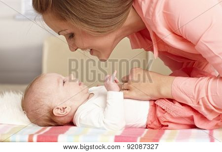 Young mother caressing baby girl tenderly.