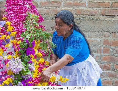 PANCHIMALCO EL SALVADOR - MAY 08 : A Salvadoran woman decorates palm fronds with flowers during the Flower & Palm Festival in Panchimalco El Salvador on May 08 2016