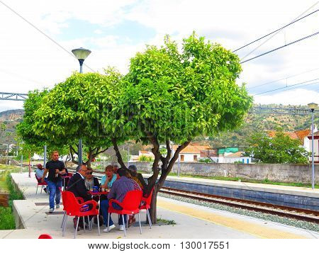 Alora Spain 23 April 2016: People enjoying Lunch under orange trees on Alora Station Platform. Alora Spain 23 April 2016