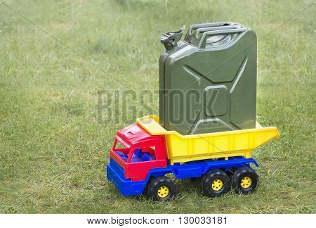 Toy car the truck with grenn canister on a gren grass