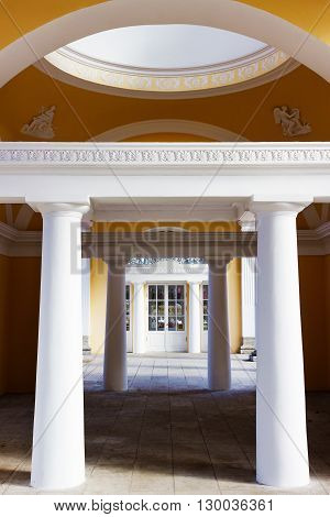 White pavilion and lake in the park of Pavlovsk on the spring sunny day. St. Petersburg. Russia