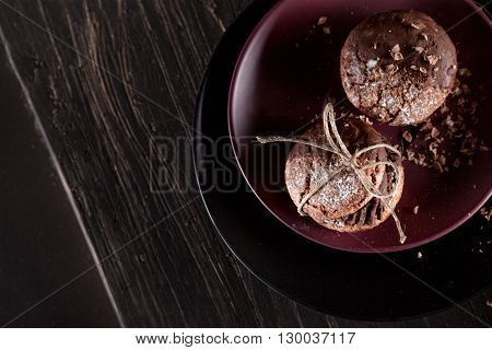 Italian maroni cookies with pieces of chocolate on old wooden background and plates