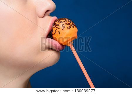Sexy girl with tasty orange colored cakepops