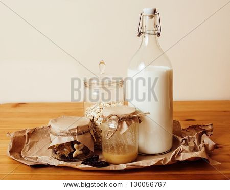 real comfort wooden kitchen with breakfast ingredients close up in glass, honey, oatmeal, milk, muesli