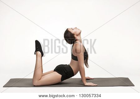 Portrait of young attractive woman doing exercises. Brunette with fit body on yoga mat. Healthy lifestyle and sports concept. Series of exercise poses.