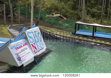 KOH PHANGANTHAILAND - NOVEMBER 25 2014 : Unidentified man jump in the pool in the attraction Slip N Fly on island Koh Phangan