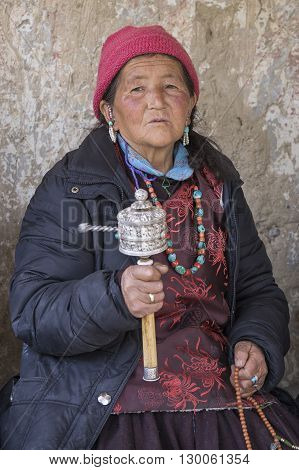 LAMAYURU INDIA - JUNE 15 2015: Unidentified buddhist old woman during mystical mask dancing Tsam mystery dance in time of Yuru Kabgyat Buddhist festival at Lamayuru Gompa Ladakh North India
