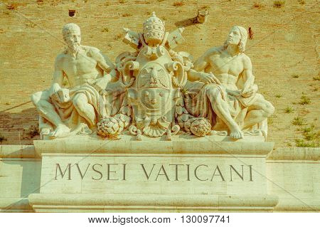 VATICAN, ITALY - JUNE 13, 2015: Wall signboard to enter to Vatican Museums, sculture with Vatican seal on stone.