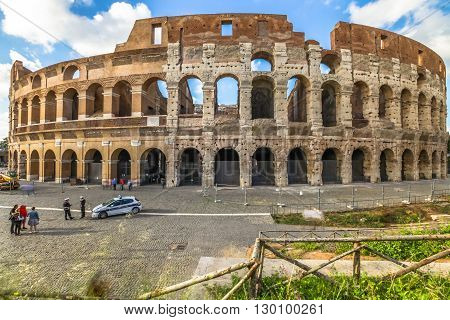 Rome, Italy - May 12, 2016: police cars, policemen and tourists in front of Colosseo, Colosseum, Flavian Amphitheatre, the largest amphitheater in the world and one of the symbols of Italy and Rome.