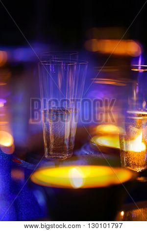 Blurred candlelit champagne glasses. Alcoholism intoxication double vision drunkenness high class party debauchery concept.
