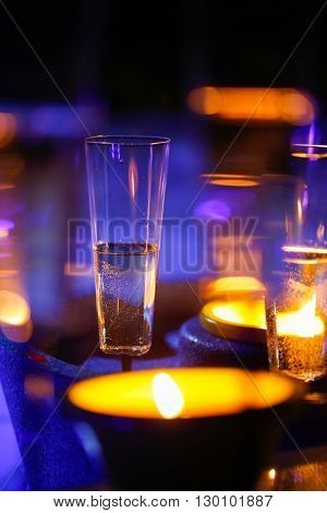 Extravagant private romantic candlelit champagne glasses with a  in the background. Love celebration relax romance luxurious vacation wellness spa concept.