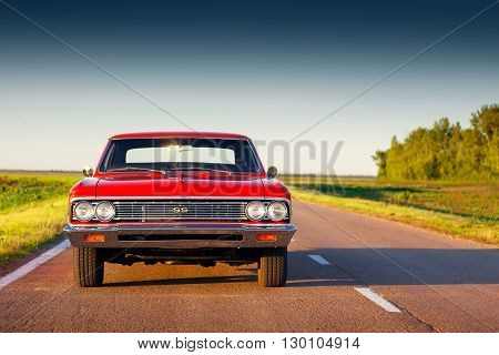 Saratov, Russia - June 07, 2015: Retro red car Chevrolet Malibu stay on asphalt road at sunset