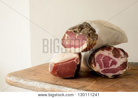 Logs of cured or preserved meat on a wooden counter