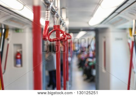 Inside the subway car. Red handrails in the subway.