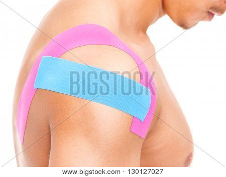 Muscular man with kinesiotaping on the shoulder, isolated on white background