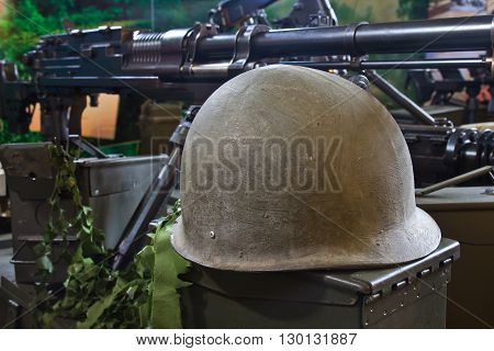 old army helmet and weapon in the background