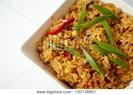 Asian fried rice with green onion, close-up on a plate