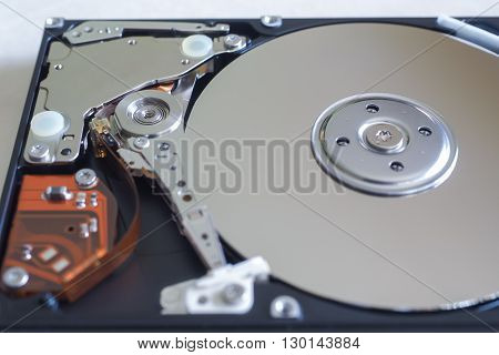 The inside of a hard disk drive showing the read/write head circuitry and platters in closeup.