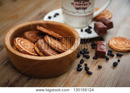 There are Cookies,Candy,Chocolate Peas,Poppy;Porcelain Saucer and Cap with Coffe,Tasty Sweet Food on the Wooden Background