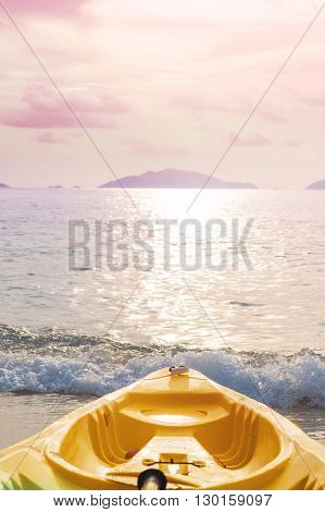 Kayak prow on tropical beach in sunset, pastel vintage tone