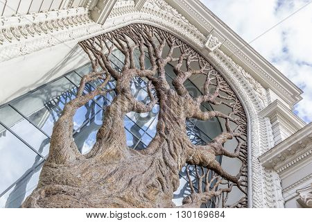 Photo taken from below of bronze tree decorating main entrance of the Palace of farmers in Kazan Tatarstan Russia.