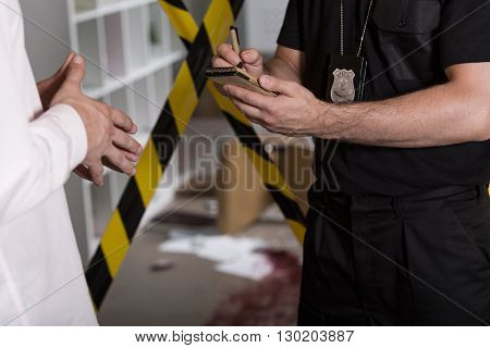 Policeman with a badge taking statement from a witness