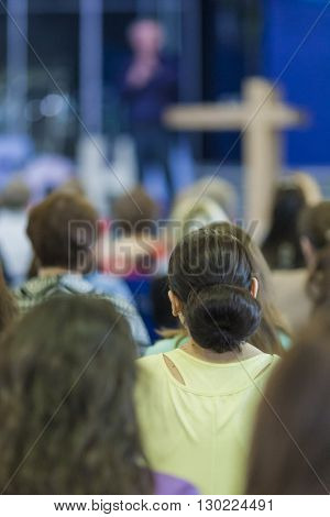 Conferences Concept and Ideas. Male Lecturer Explaining and Performing On Stage In front of the Large Group of People. Horizontal Image Composition