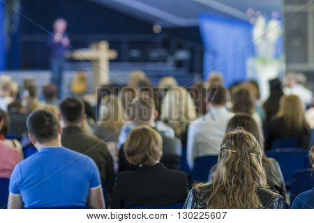 Conferences Concept and Ideas. Male Leader Lecturer Speaking In front of the Large Group of People. Horizontal Image Composition
