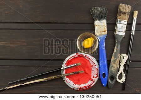 Brushes and paint on a wooden table. Painter tools. Workshop painter. Needs painting. Sales painting needs. Clutter on the workbench. Sales of color. Advertising on painting.