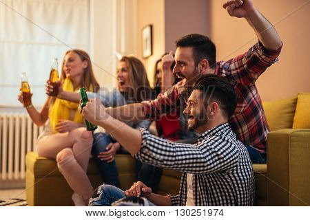 Friends enjoying a great football game and drinking beer.