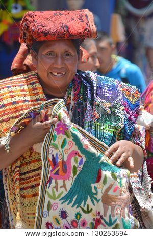 CHICHICASTENANGO GUSTEMALA APRIL 29 2016: Portrait of a Mayan woman saling table cloth. The Mayan people still make up a majority of the population in Guatemala,