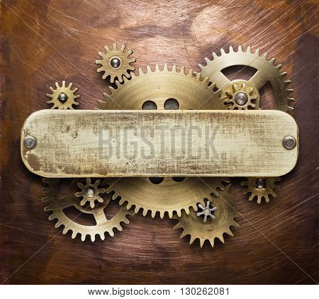 Clockwork mechanism collage on copper background made of metal gears, brass plate.