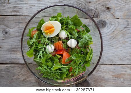 Glass bowl of fresh mixed arugula salad